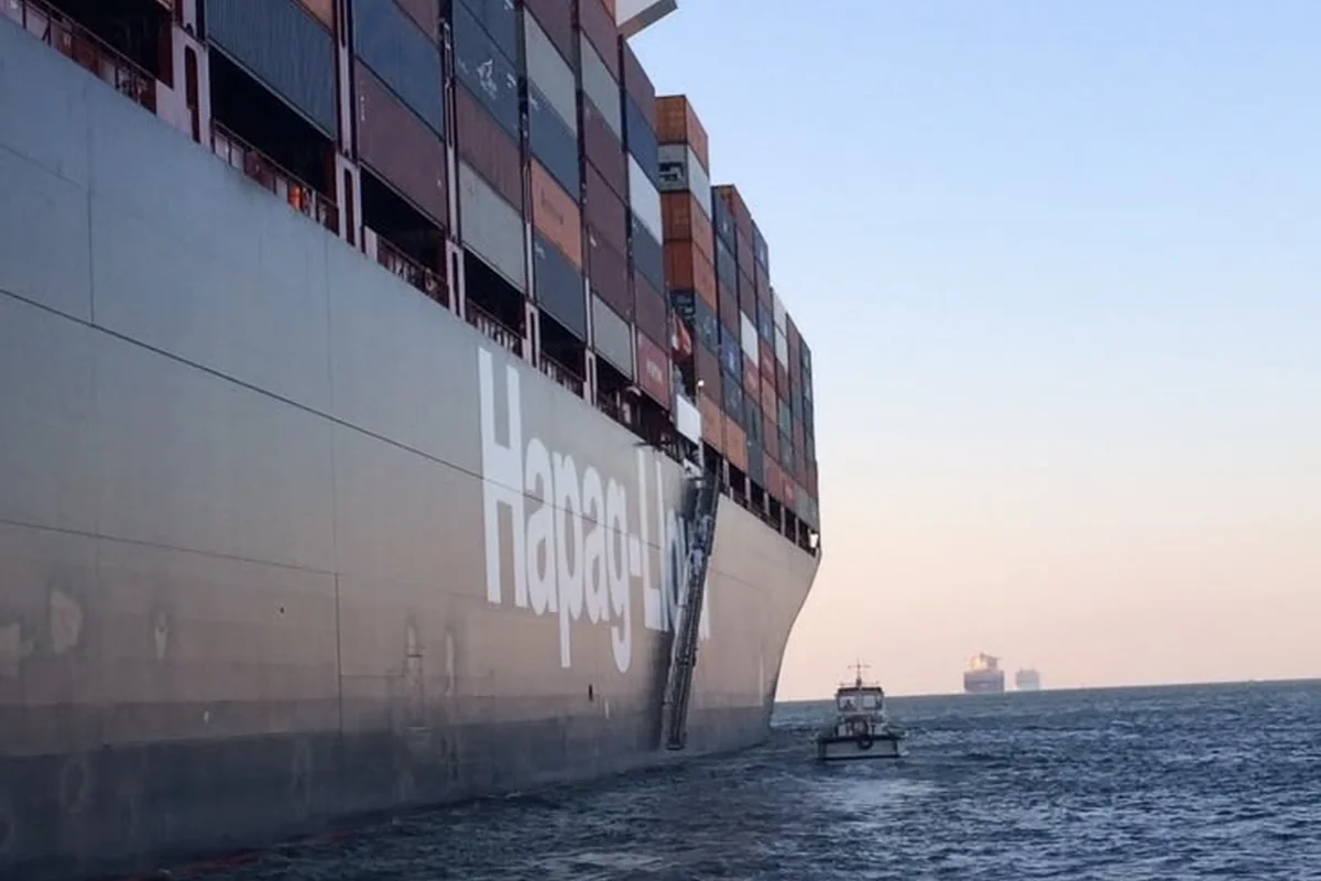 Boat servicing a container vessel at sea